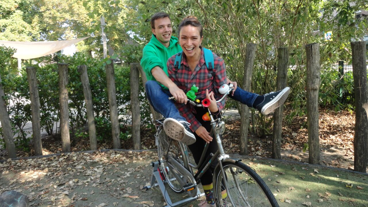 Twee mensen zitten op een fiets in een toneelstuk