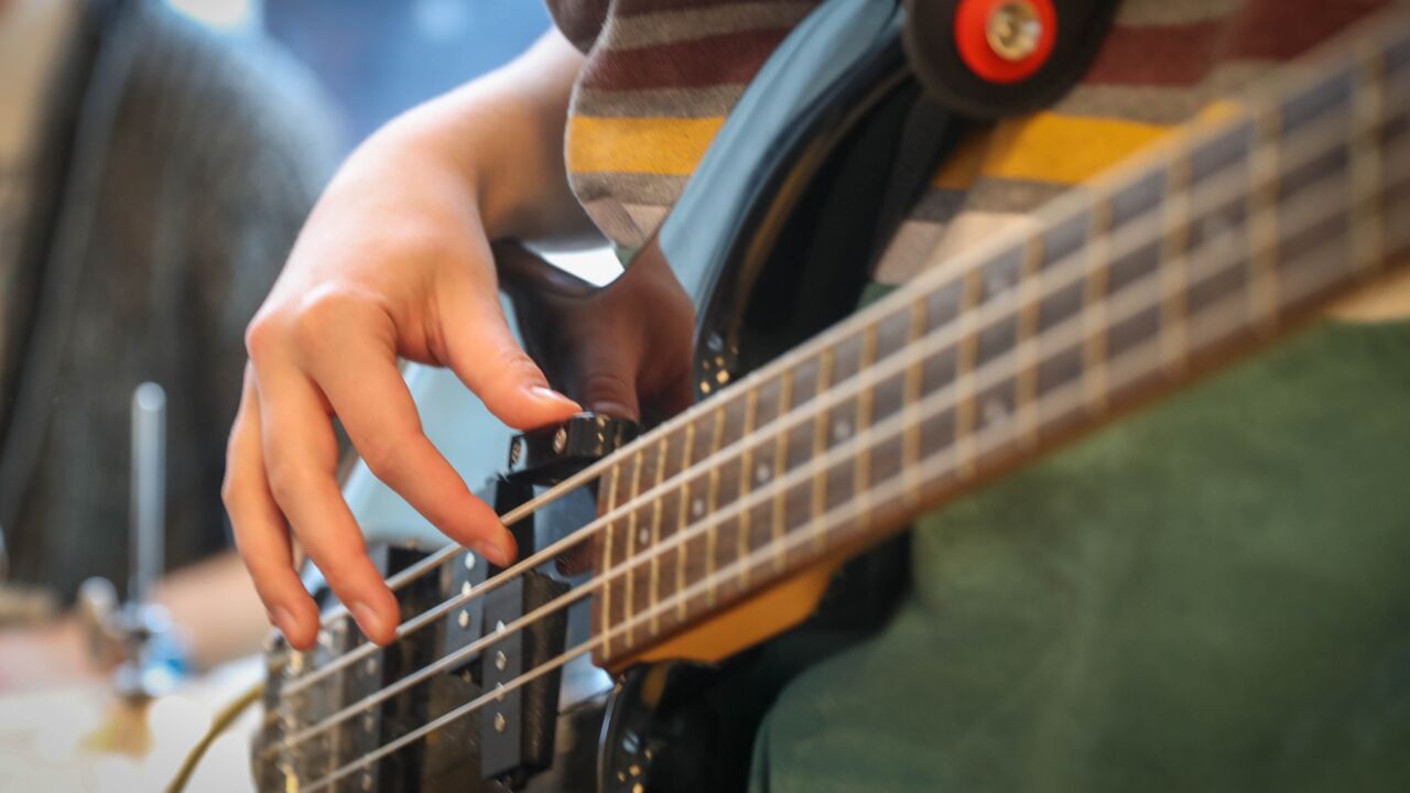 Vingers die spelen op een basgitaar
