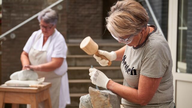 Cursist is bezig met steenbewerking