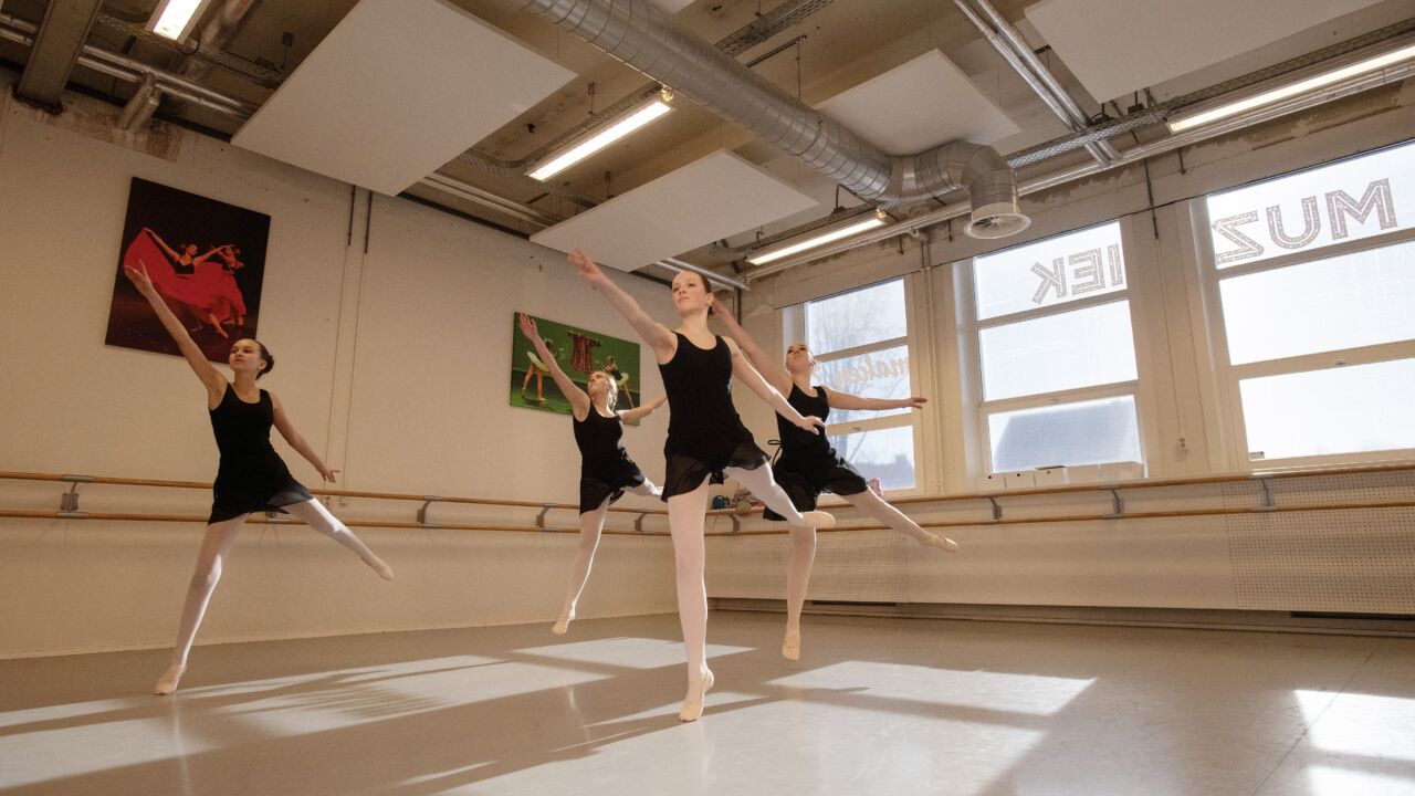 Een groep leerlingen krijgt les in klassiek ballet.