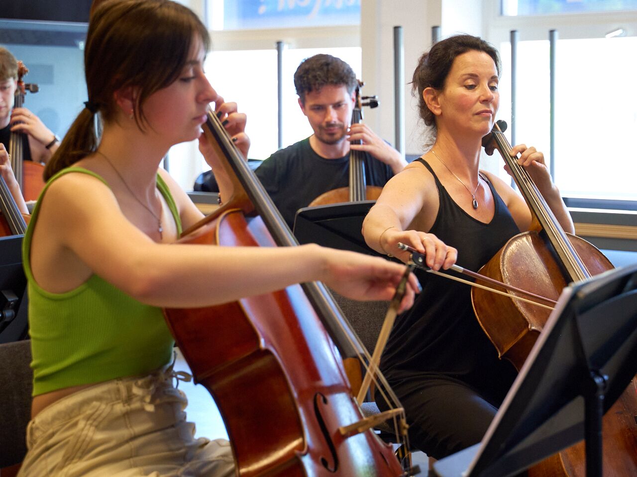 Een groep cursisten speelt cello