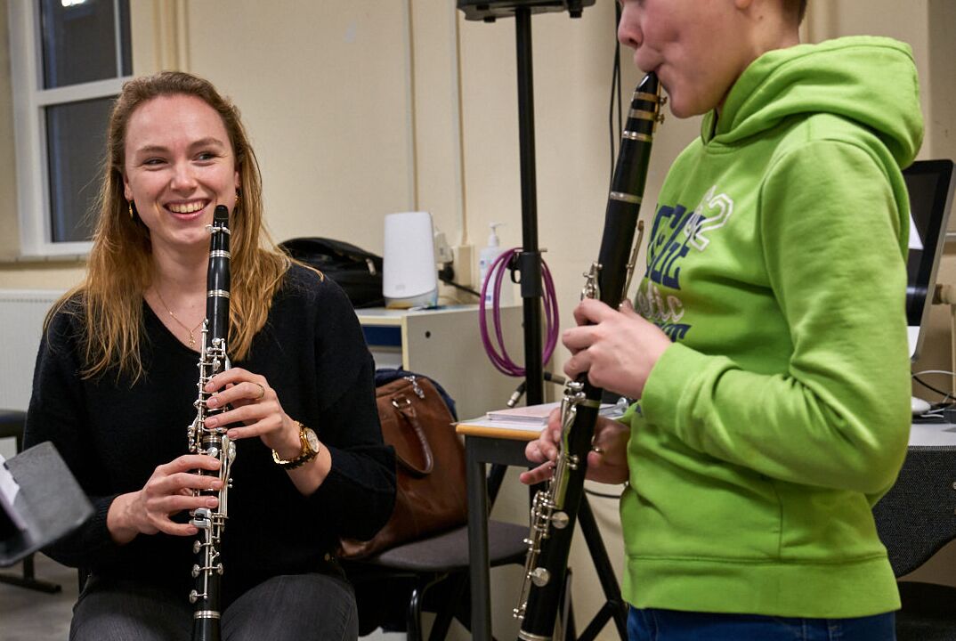 Kind volgt muziekles en docente kijkt mee