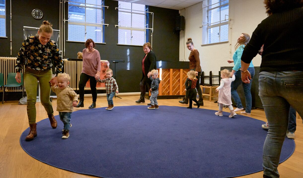 kindjes lopen samen met ouders in een rondje