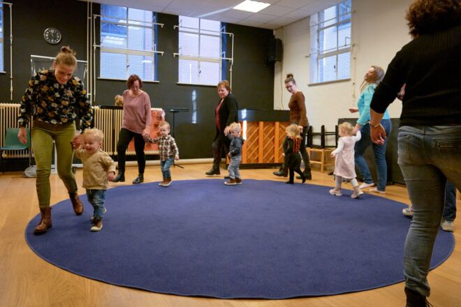 kindjes lopen samen met ouders in een rondje