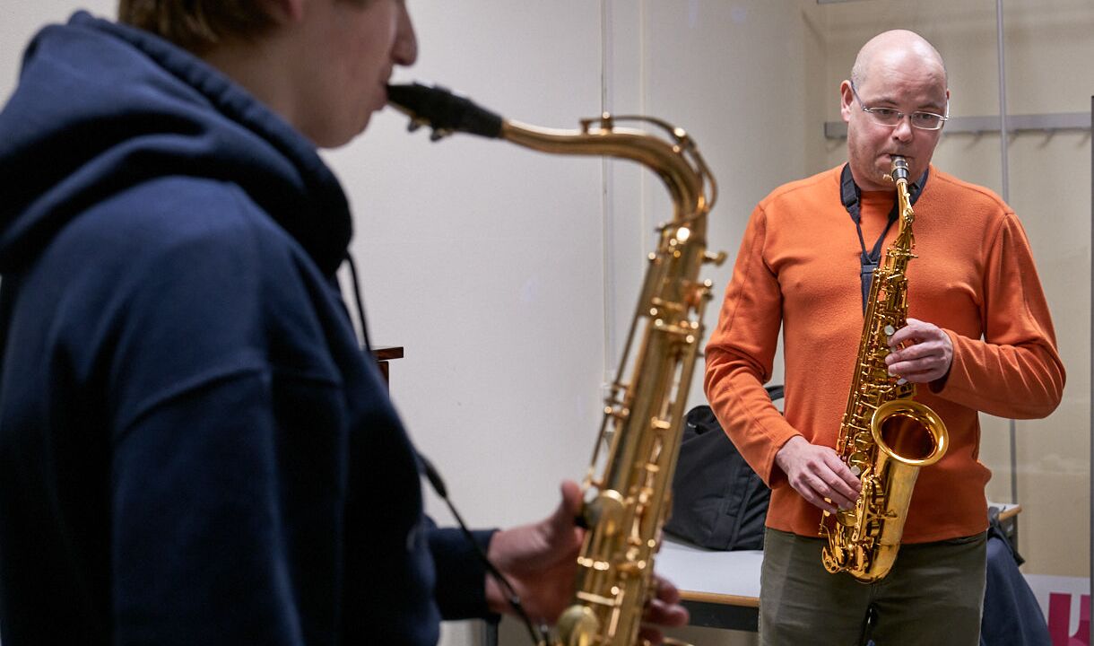 Twee muzikanten spelen ieder op eigen saxofoon