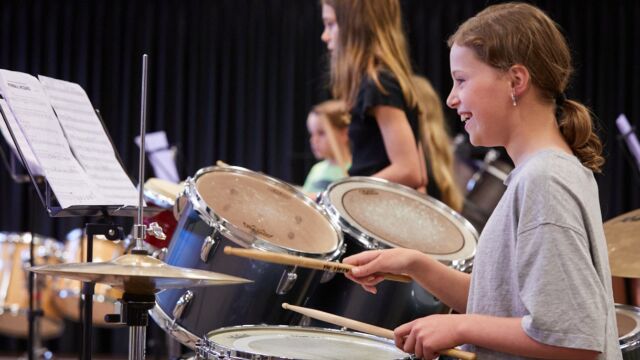 Een aantal kinderen in een muziekvereniging spelen samen.