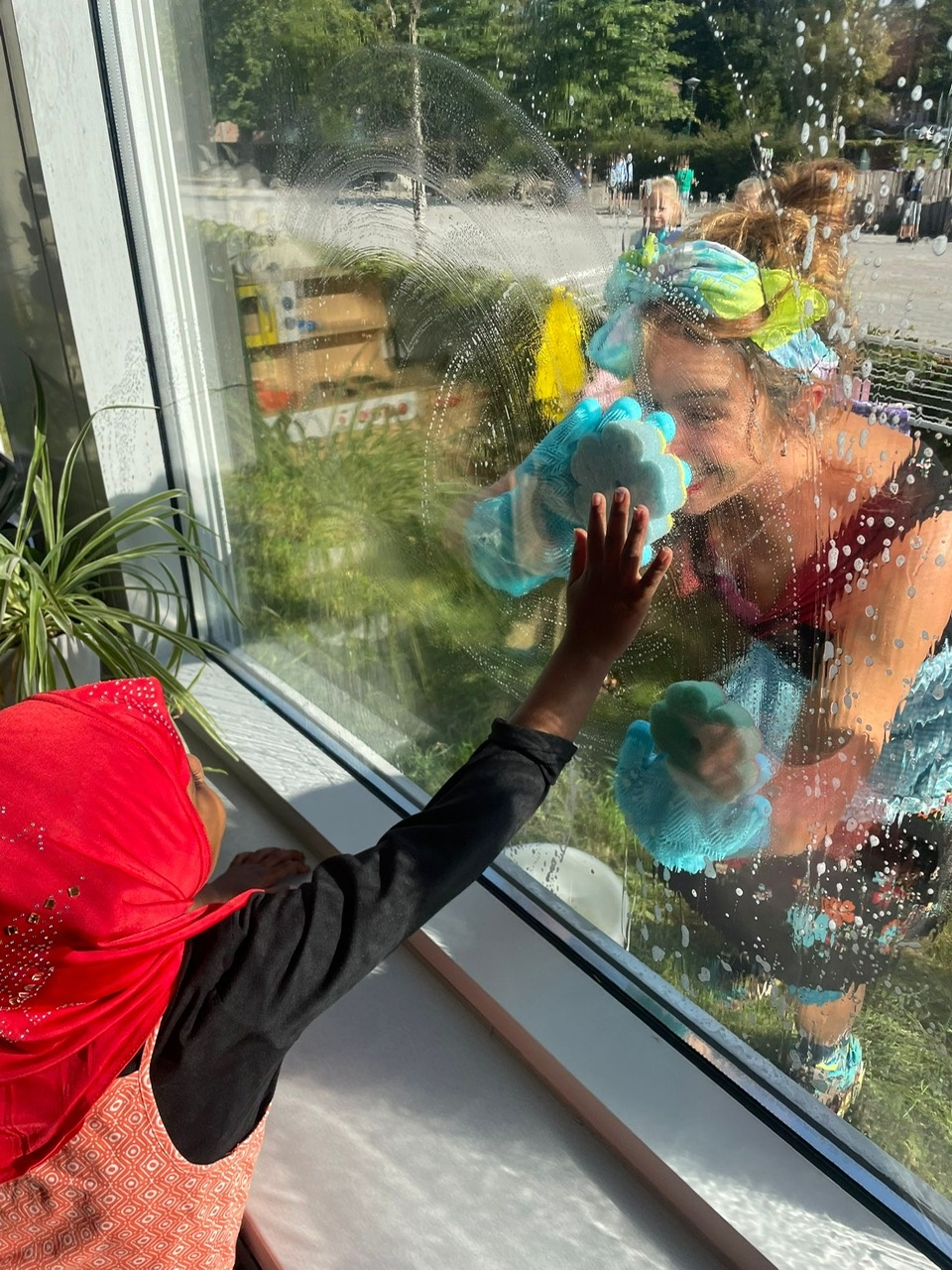 Een meisje maakt contact door het raam met de theatermaker tijdens de voorstelling ZEEP